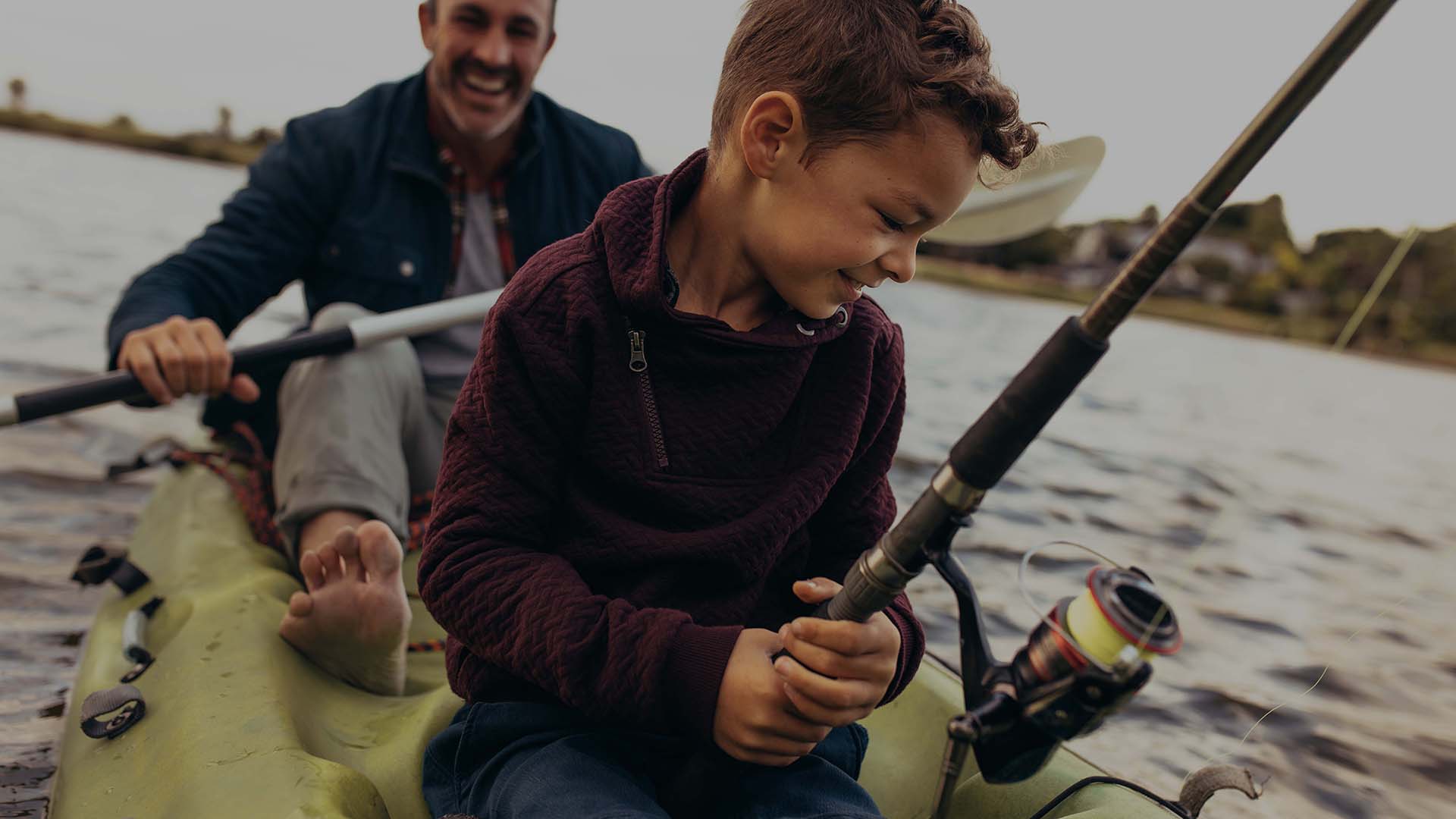 Father and son enjoying fishing in the lake
